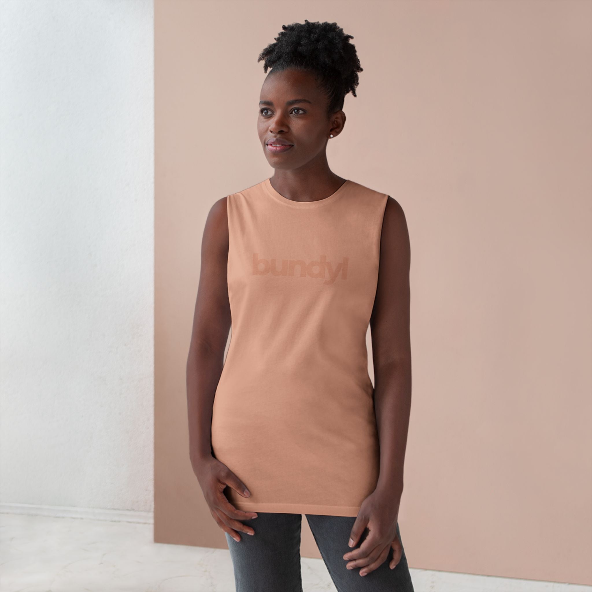 Woman wearing a sleeveless peach top against a neutral background