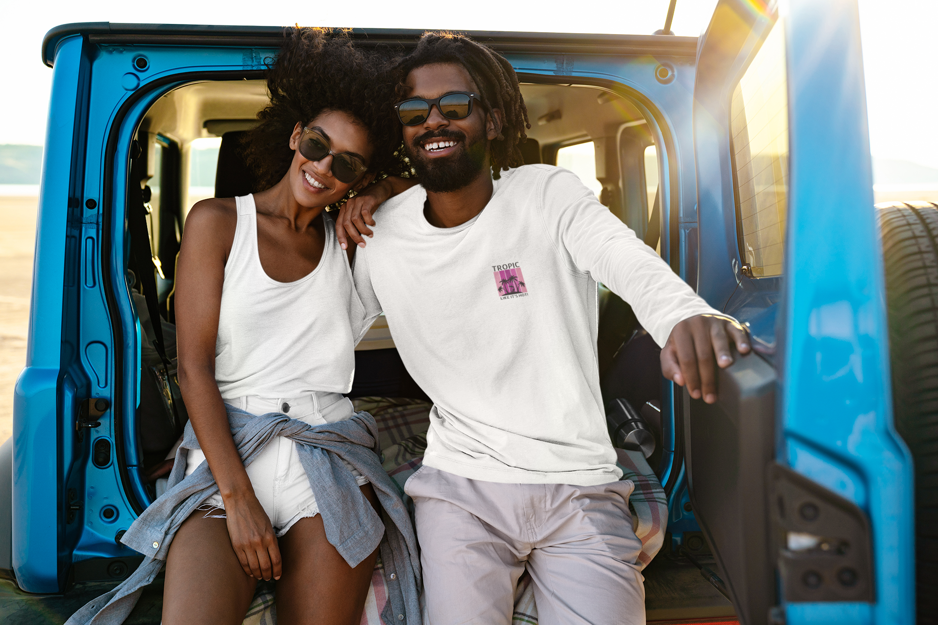 Two people sitting in an open blue vehicle with a scenic background